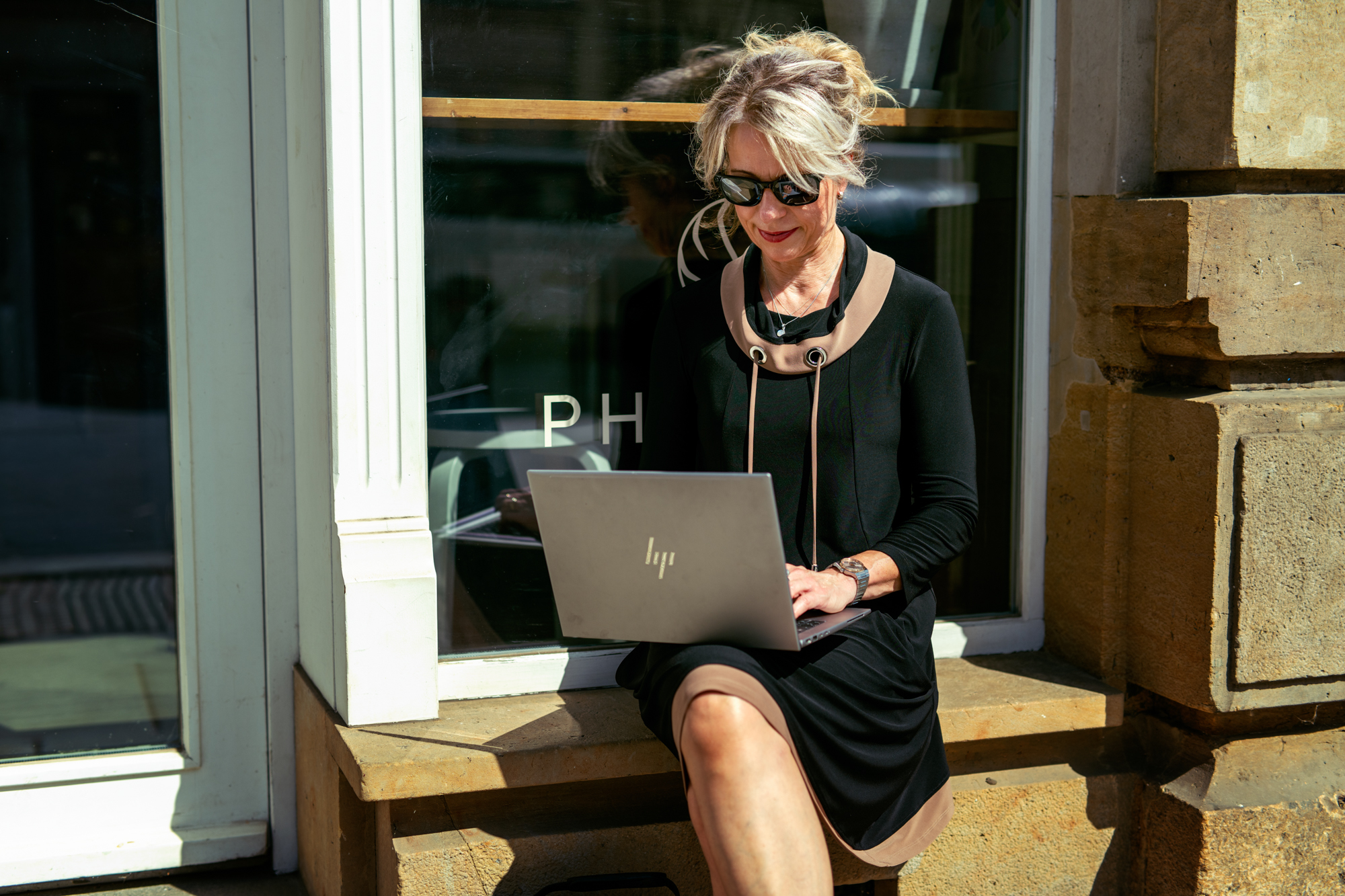 Coach am Laptop vor dem Café